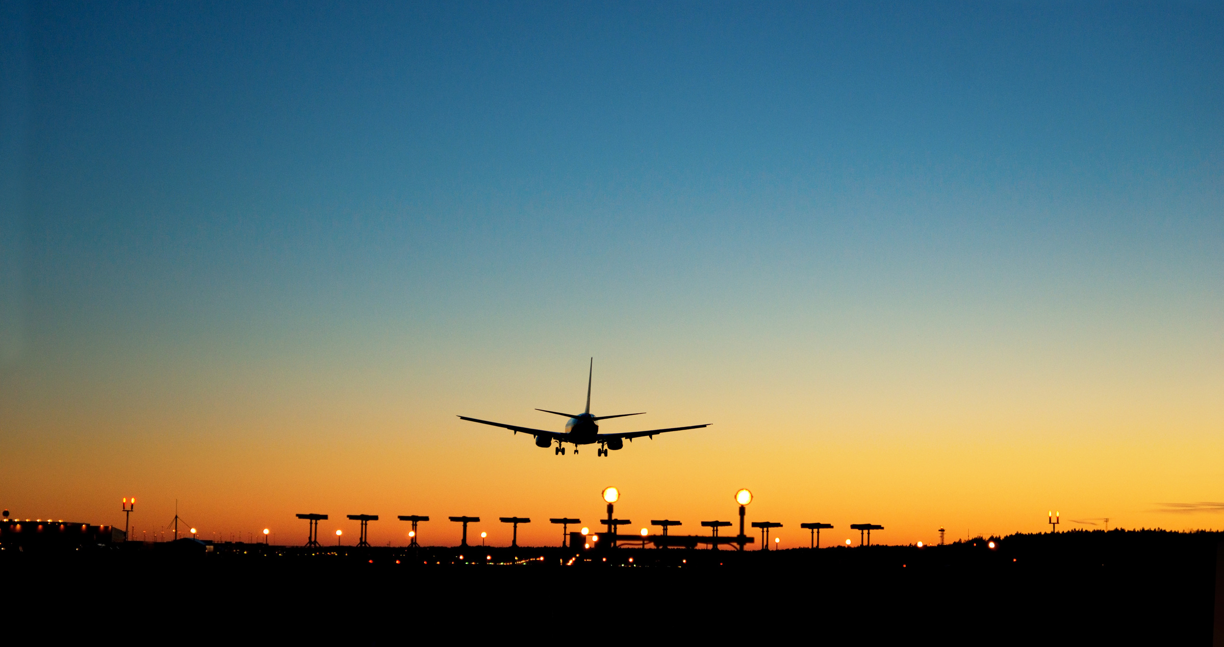 aircraft approaching airport at sunset